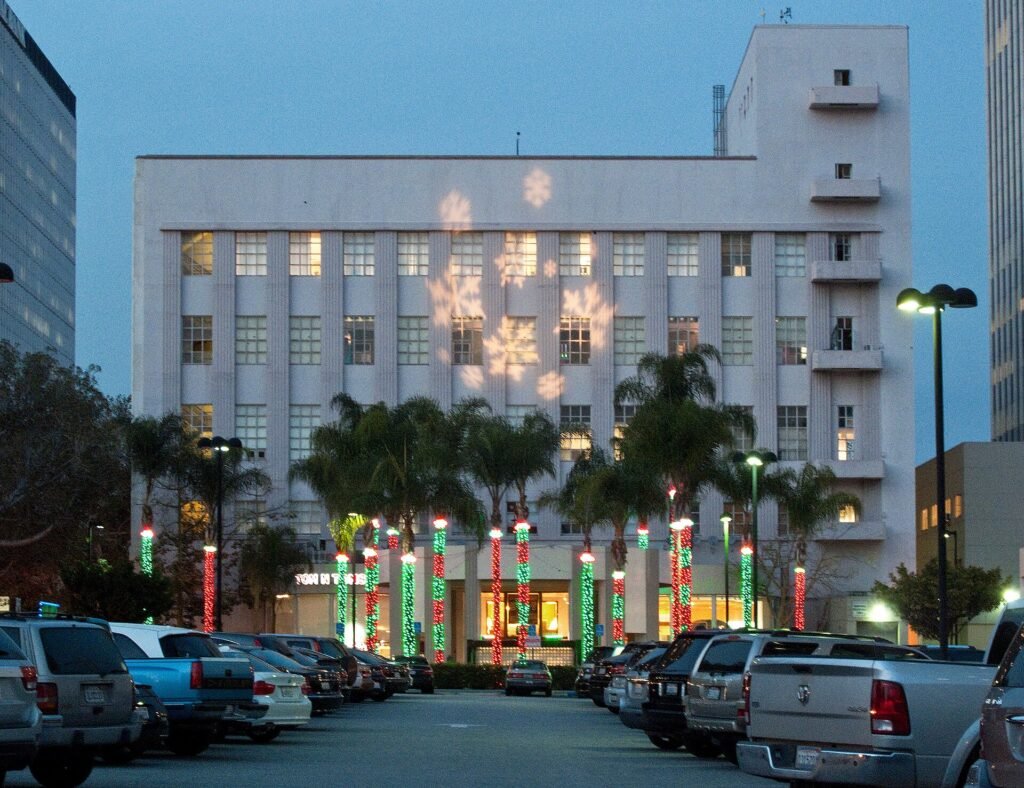 Palm trees wrapped in red and green holiday lights on Wilshire Boulevard